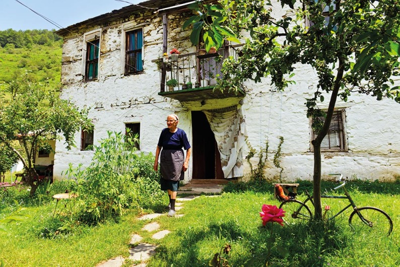 Olga Gramosli (79) gjorde som de fleste naboene i Maloviste og flyttet til byen Bitola da ungene skulle gå på skole. Men hver sommer bytter hun leir, og nyter frisk luft og hagestell. Foto: Gjermund Glesnes 