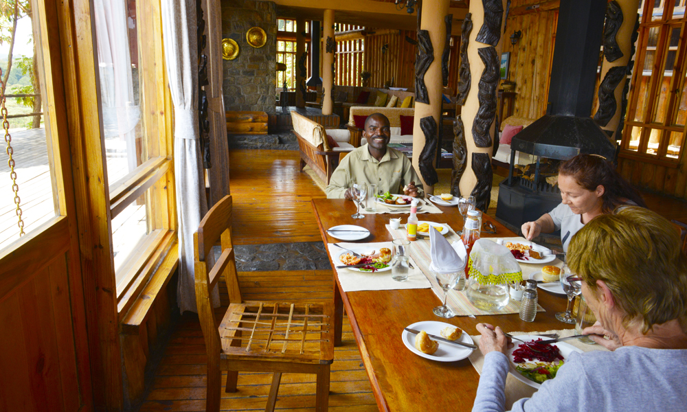 Med bare tre gjester på hele Chelinda Lodge blir det naturlig å sitte sammen til bords ved måltidene. Og på hedersplassen ved enden av bordet sitter hovedguide Whyte Mhone. Foto: Gjermund Glesnes