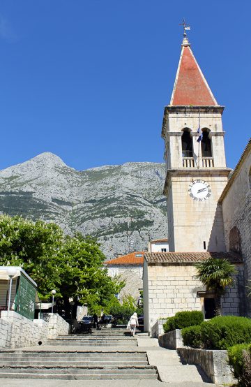 St. Markuskirken er torgets hpvedattraksjon. Den ble påbegynt av biskopen Bjanković av Makarska i 1700, og huser i dag blant annet en stor samling av sølvsmykker fra 1700- og 1800-tallet. Bak skimtes de mektige Biokovo-fjellene. Foto: Ida Anett Danielsen 