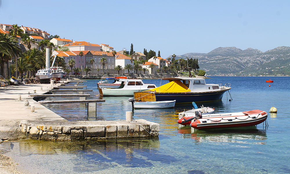 Havnen i Korčula by er delt i to – på den ene siden ligger små fiskebåter, mens cruisebåter og ferger legger til på den andre. Foto: Ida Anett Danielsen