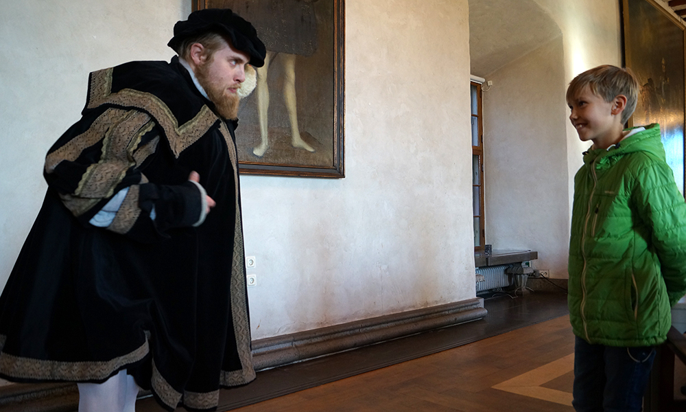 Kong Gustav Vasa gir Oskar Nicolai (8) en leksjon hvordan en bør kle seg og se ut for å være en skikkelig konge. Man skulle være tjukk, skjeggete og gå med hvite strømpebukser. Foto: Trude Grande Fjellbirkeland