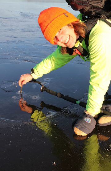 Torill Lundh sjekker isens tykkelse med en medbragt måler, og forsikrer gjengen om at den er trygg. Foto: Ida Anett Danielsen 