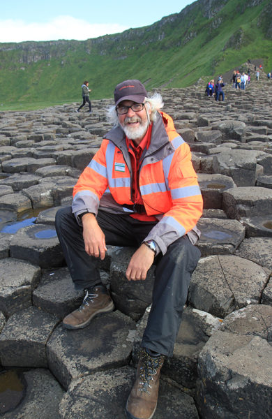 Philip Robinson (58) jobber som vakt ved Giants Causeway, og forklarer gjerne historien og mytene bak steinformasjonene. Foto: Runar Larsen 