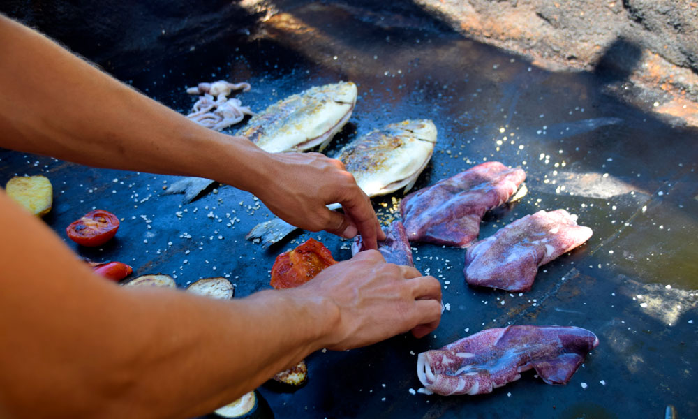 La kokken på den lille strandrestauranten på Utopia grille fersk "dorada" og "calamari" til deg, mens du tar et svalkende bad. Foto: Mari Bareksten